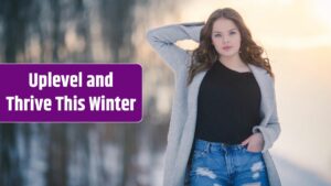 Young female wearing jeans and a black shirt paired with a cardigan in a field covered in the snow.