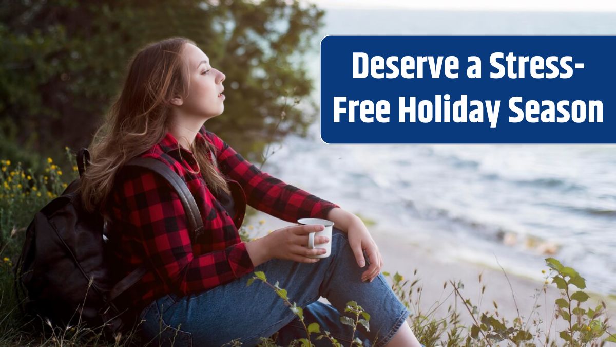 Mid shot brown haired woman sitting on ground looking at sea.