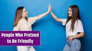 Two happy young women with different hair giving high five to each other isolated over blue wall.